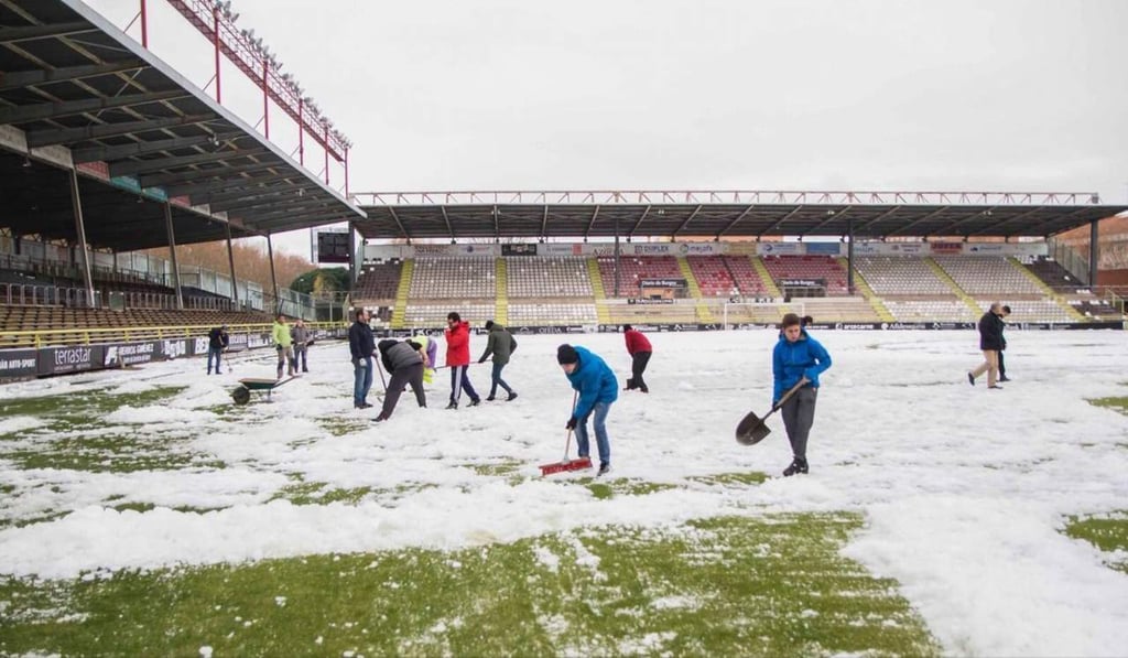 Aficionados ayudan al Burgos a retirar nieve del campo