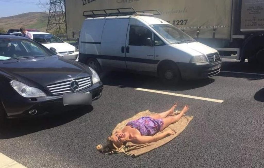 Mujer toma el sol en plena carretera durante accidente