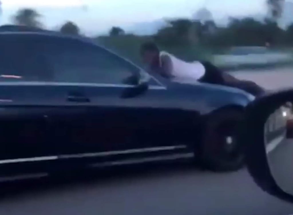Hombre visto arriba de un auto en una carretera de Florida