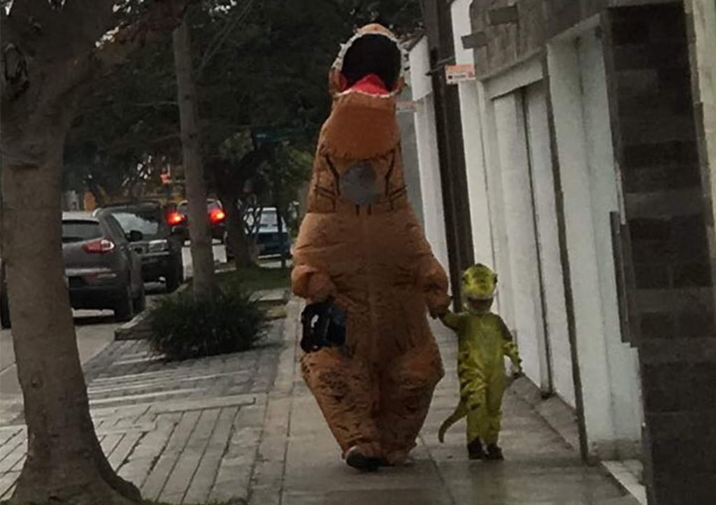 Papá lleva a la escuela a su pequeño con disfraz de dinosaurio