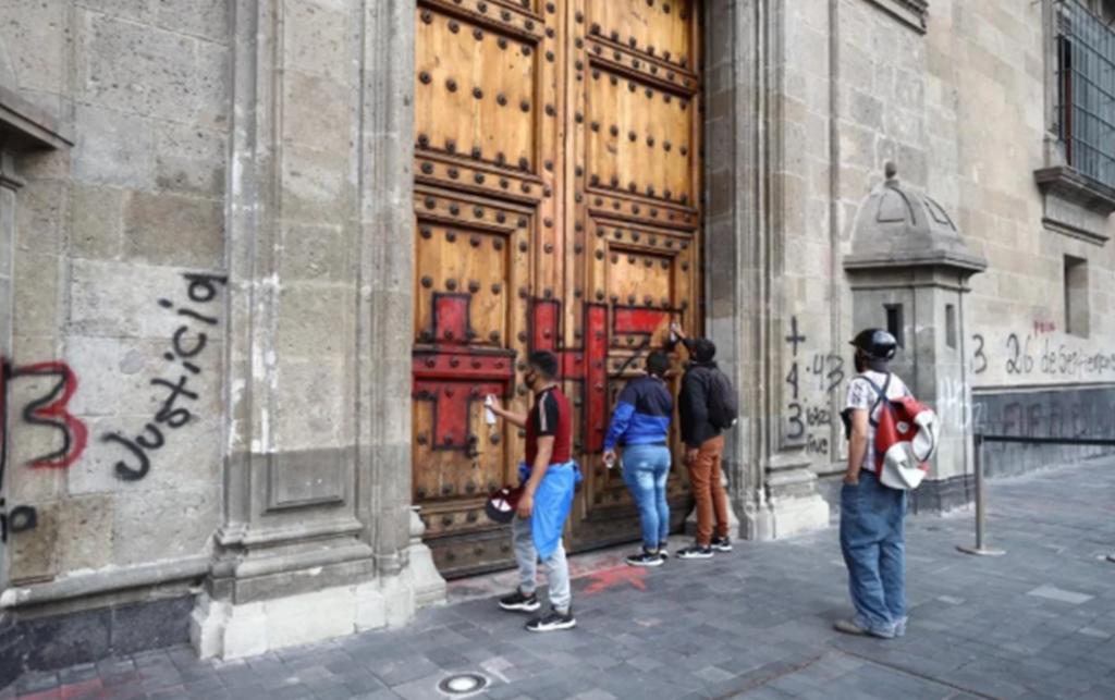 Hacen pintas en Palacio Nacional tras concluir la marcha por Ayotzinapa