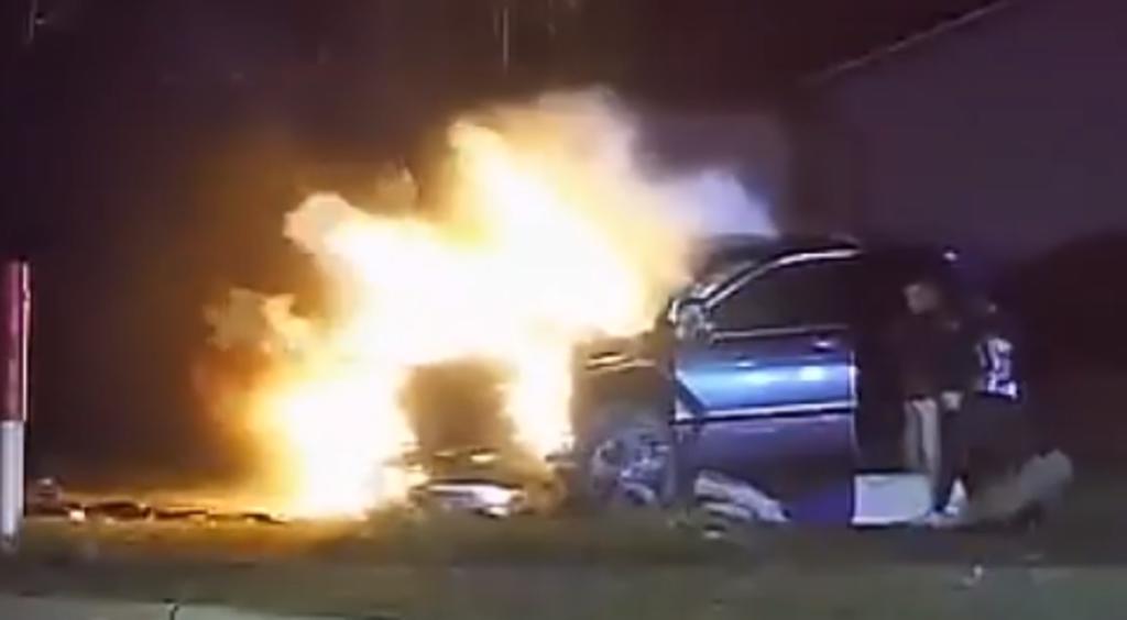 Oficiales de policía rescatan a un hombre en estado de ebriedad de un auto en llamas