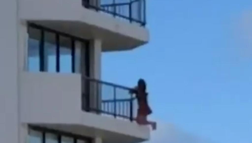 Mujer es grabada colgando desde un balcón para posar para una foto