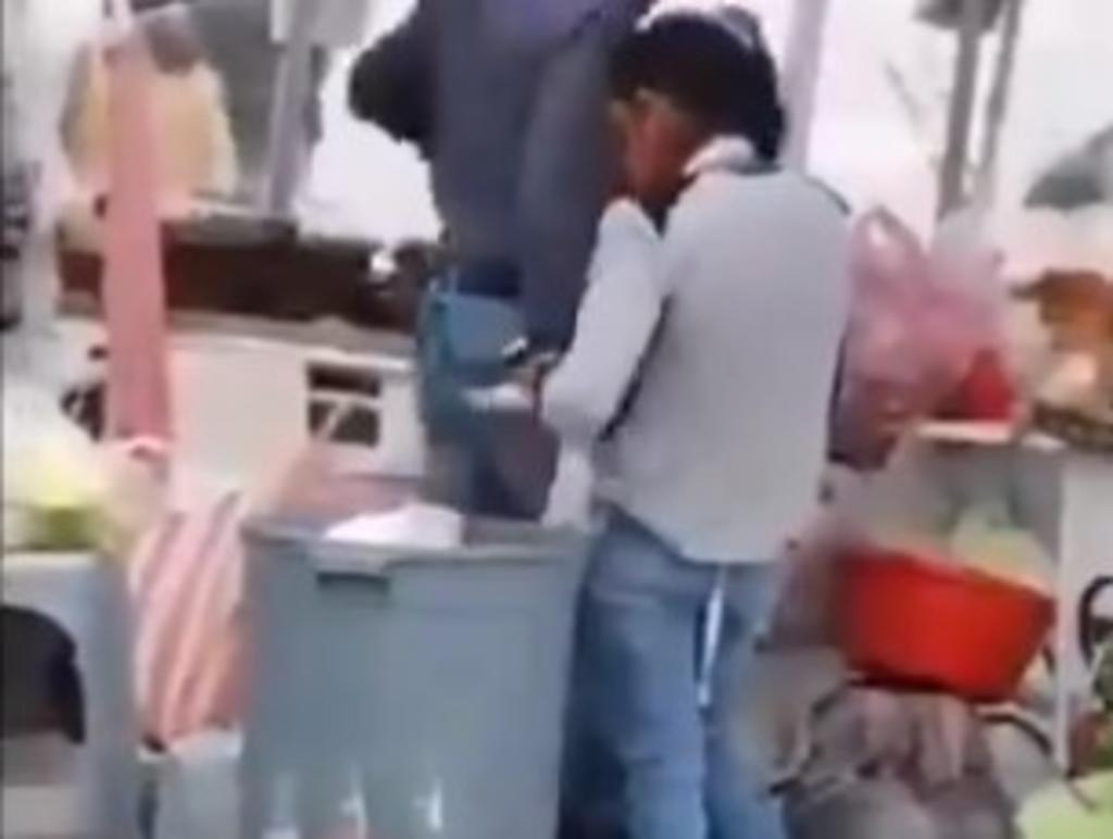 Exhiben a vendedora de comida sacando platos de la basura para reusarlos