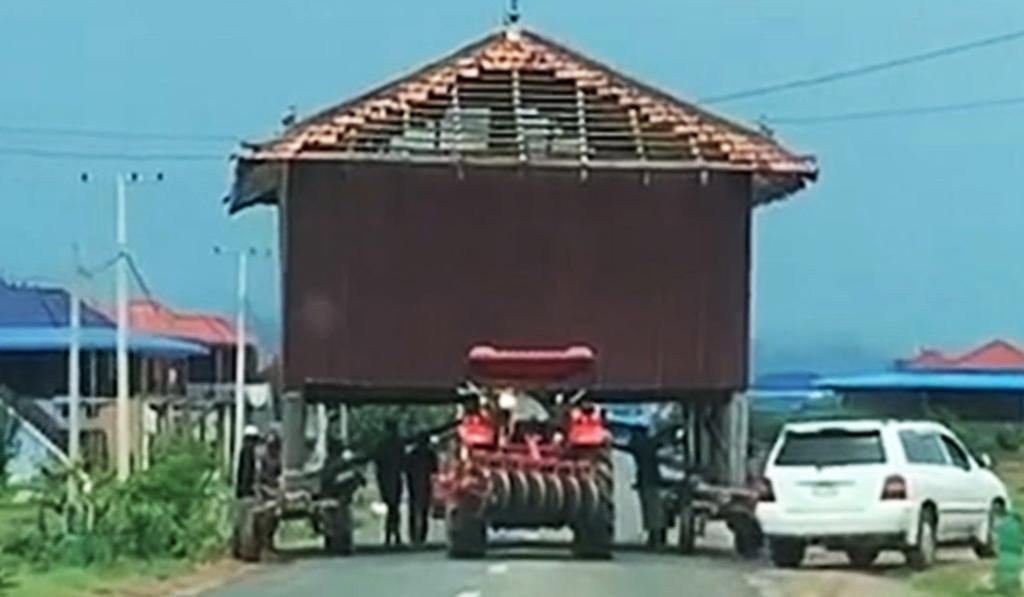 Personas son grabadas transportando una casa utilizando un tractor