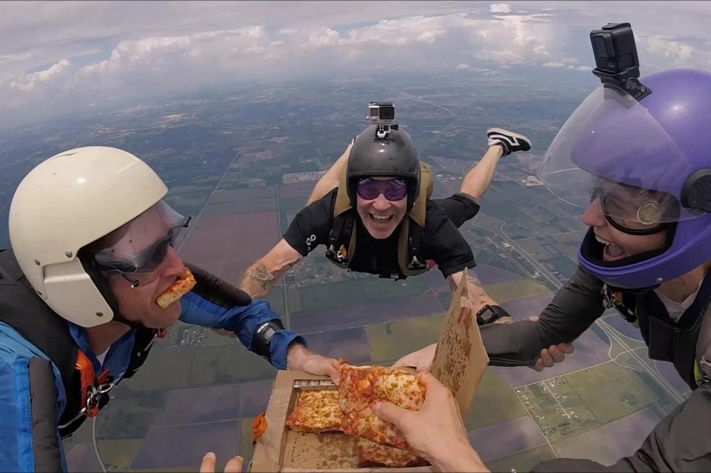 Paracaidistas comen pizza mientras caen de una altura de 4 mil metros