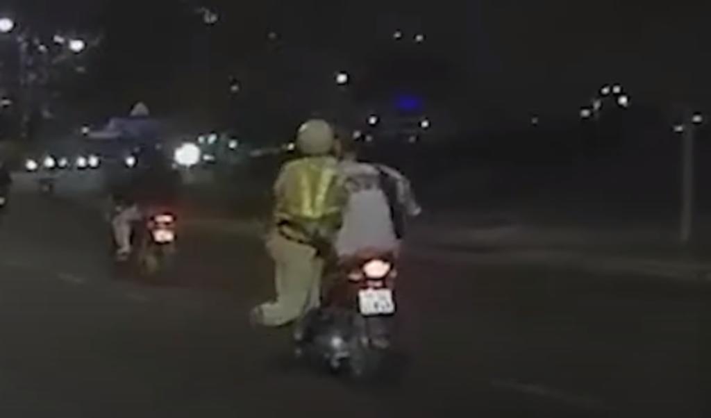 Policía se aferra a motociclista que intentó huir para evadir una multa