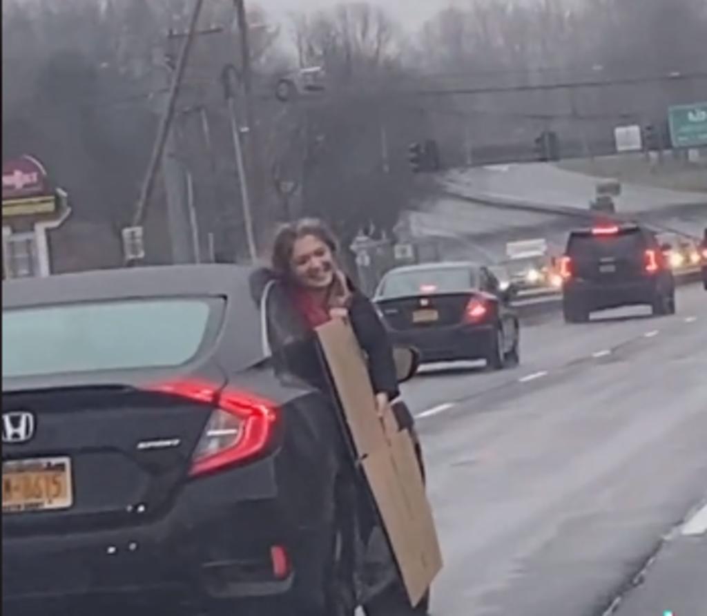 Mujer cuelga desde la ventana de un auto por estar cargando una caja de cartón y se vuelve viral