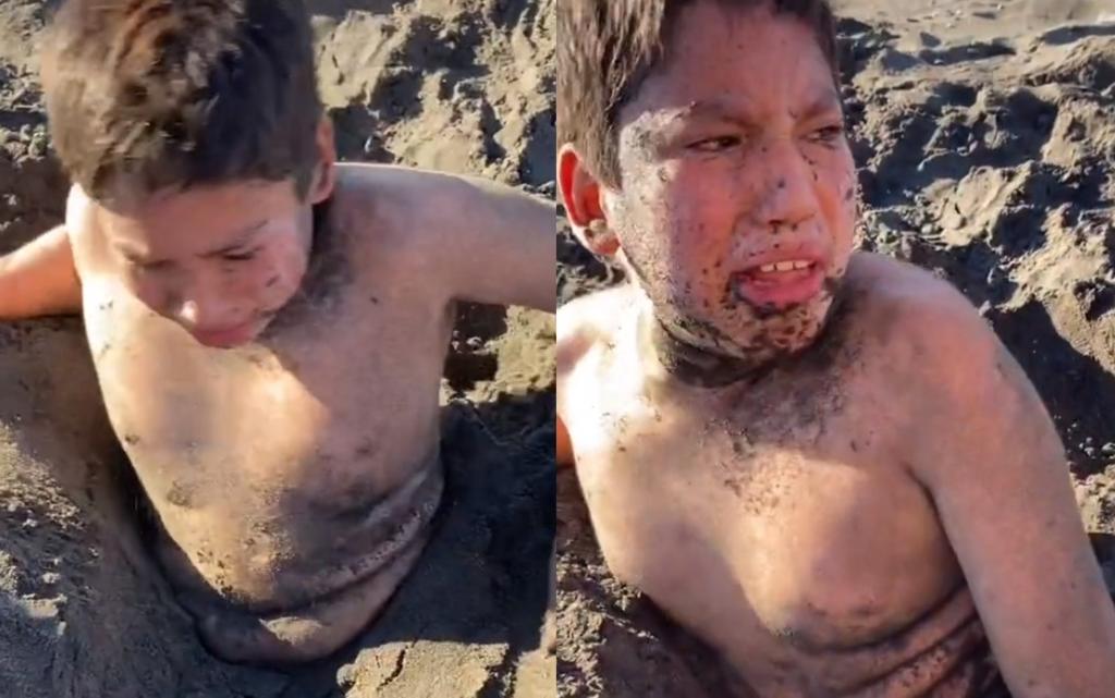 'Son una mie... de familia'; niño se vuelve viral por su reacción al ser enterrado en la arena