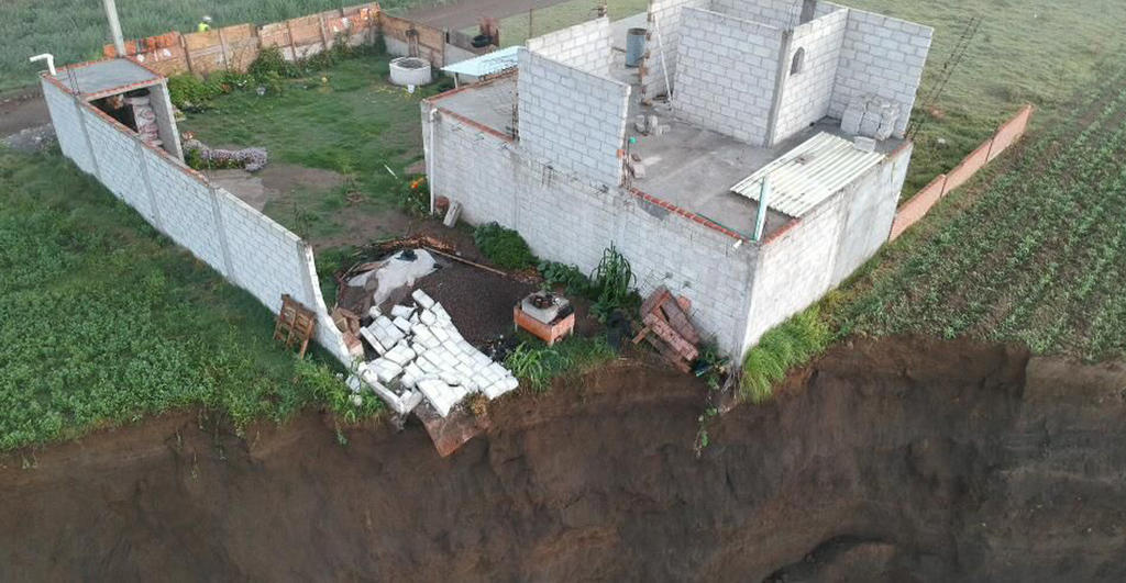 Cae casa que se encontraba pendiendo del socavón en Puebla