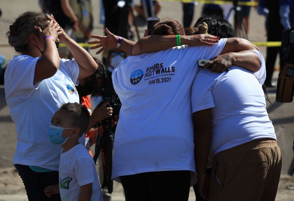 Familias migrantes se abrazan en la frontera