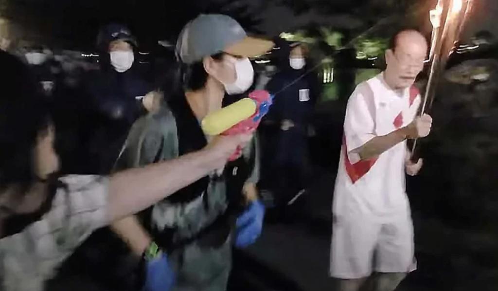 Mujer intenta apagar la antorcha olímpica con una pistola de agua y es arrestada