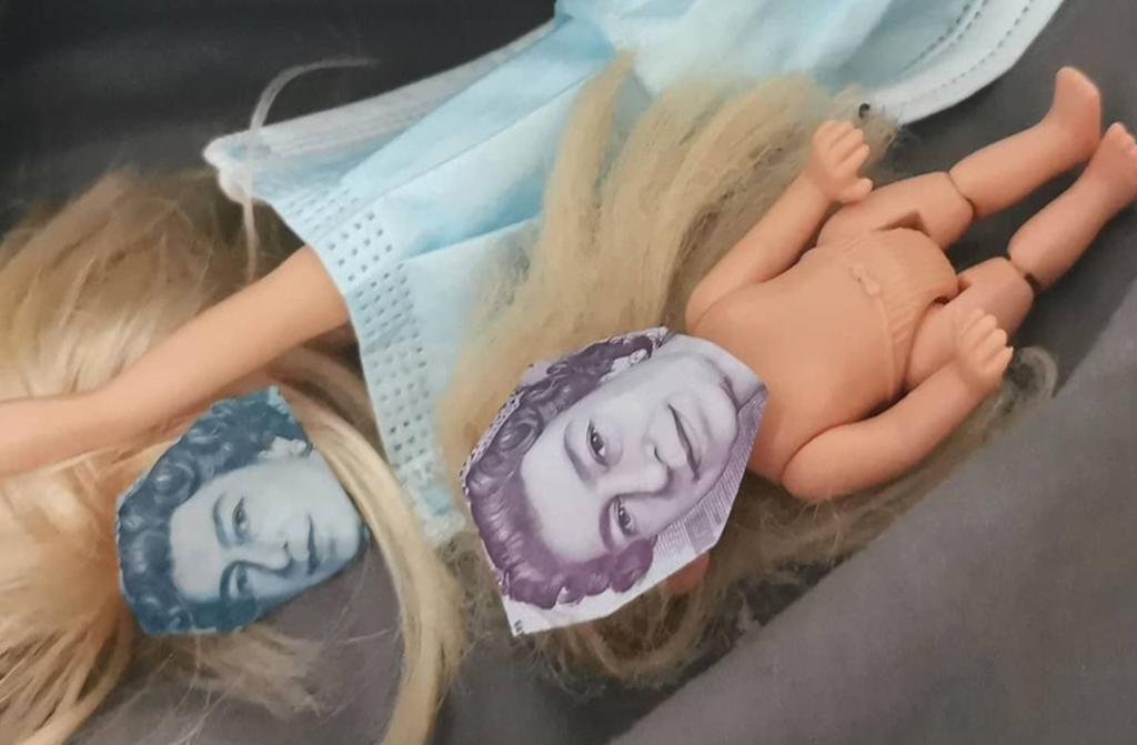 Niña recorta billetes de libras esterlinas para poner la cara de la reina en sus muñecas