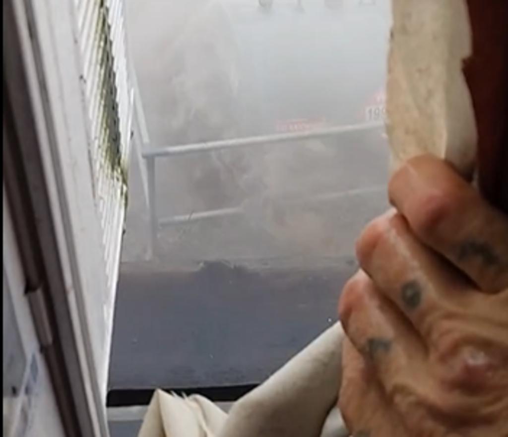 Hombre abre una ventana en pleno huracán para mostrar la intensidad del viento