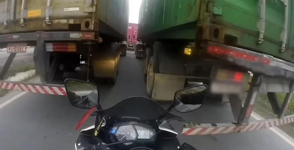 Motociclista intenta pasar entre dos camiones y por poco es atropellado