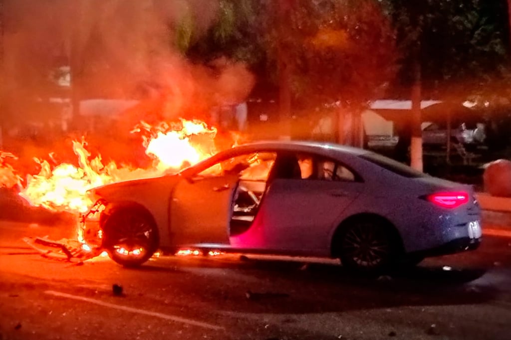 Se incendia y abandonan lujoso automóvil tras chocar con luminaria en Heroico Colegio Militar