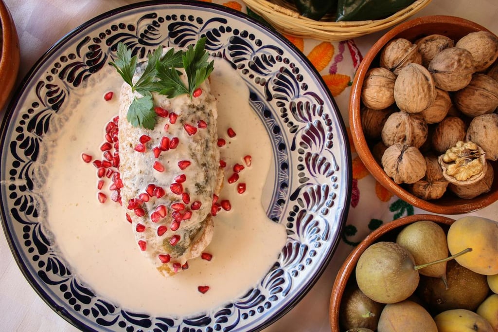 Ingredientes. Chile poblano como base, relleno con un picadillo que mezcla carne de res y cerdo con frutas criollas de temporada como manzana panochera, pera lechera, durazno y plátano macho, además de almendra, pasas, piñón rosa y especias son todo lo que constituye un buen Chile en Nogada.