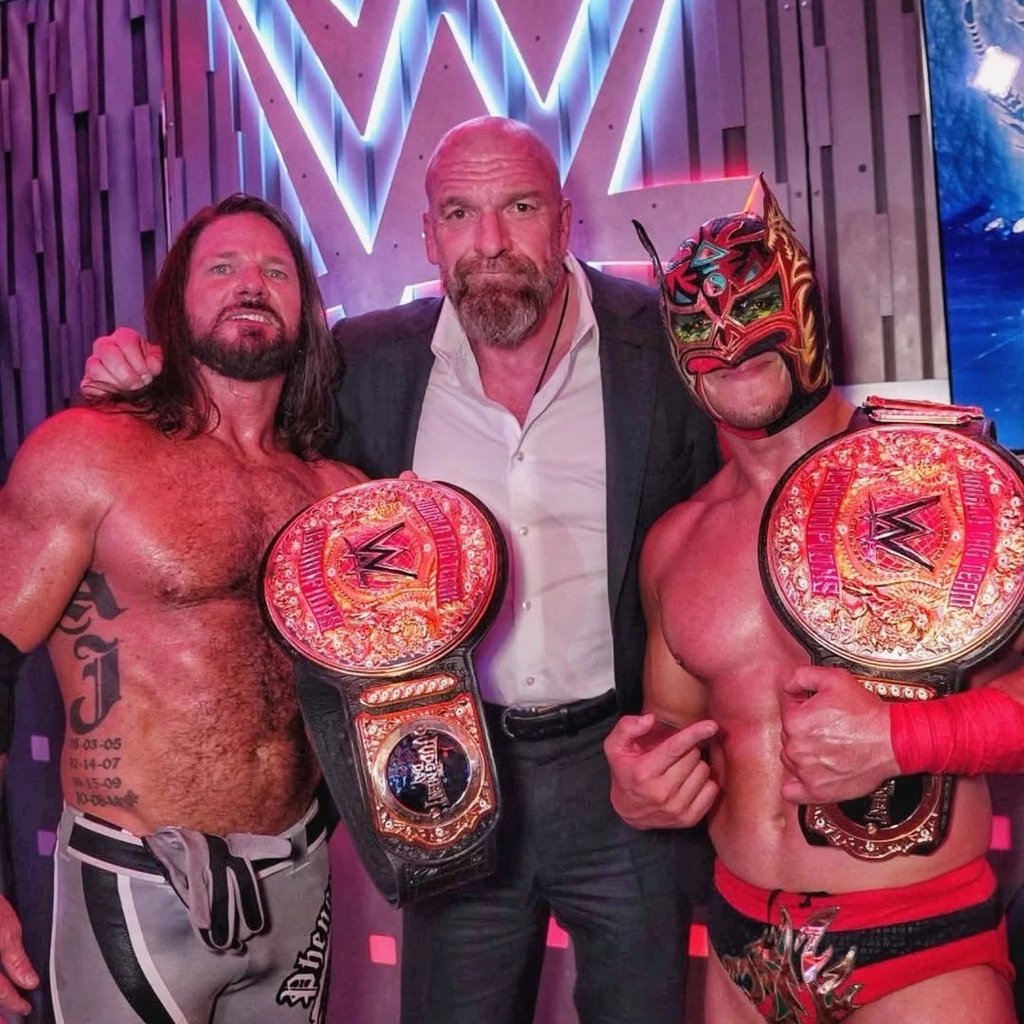 Monarcas. Triple H con los nuevos campeones World Tag Team, AJ Styles y Dragon Lee.