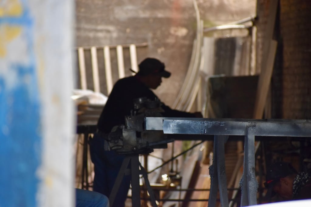 Continúan. Un herrero da forma al metal en su taller, un oficio escaso en la ciudad.