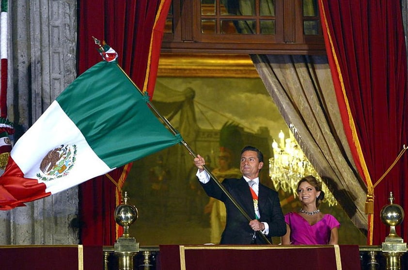 En punto de las 23:00 horas, el primer mandatario embrazó la Bandera Nacional, salió al balcón acompañado de su esposa Angélica Rivera y recordó a los héroes que iniciaron la lucha de independencia hace 204 años.