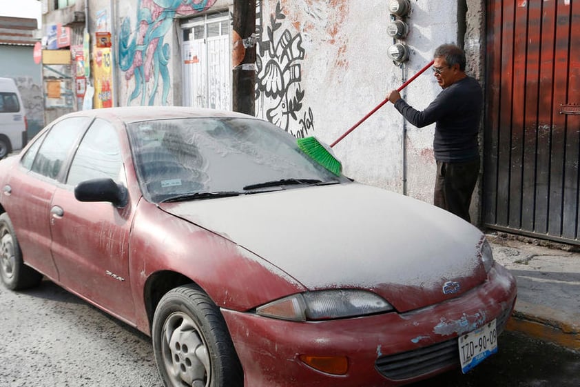 La población salió a limpiar sus vehículos de la ceniza.