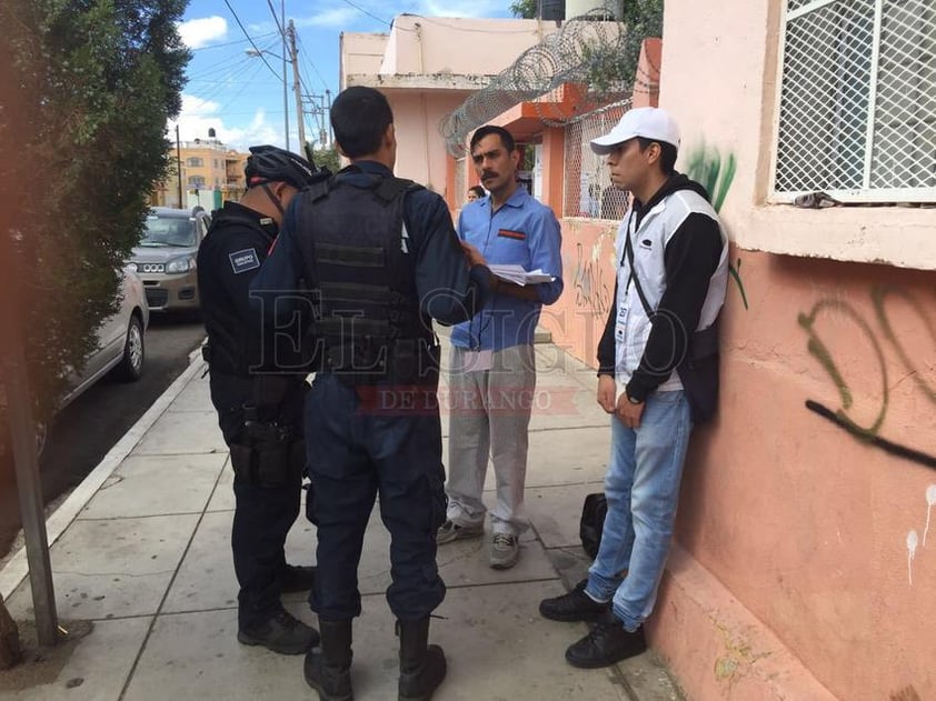 Policías hablando con encuestadores de salida de la casilla de la primaria Benito Juárez.