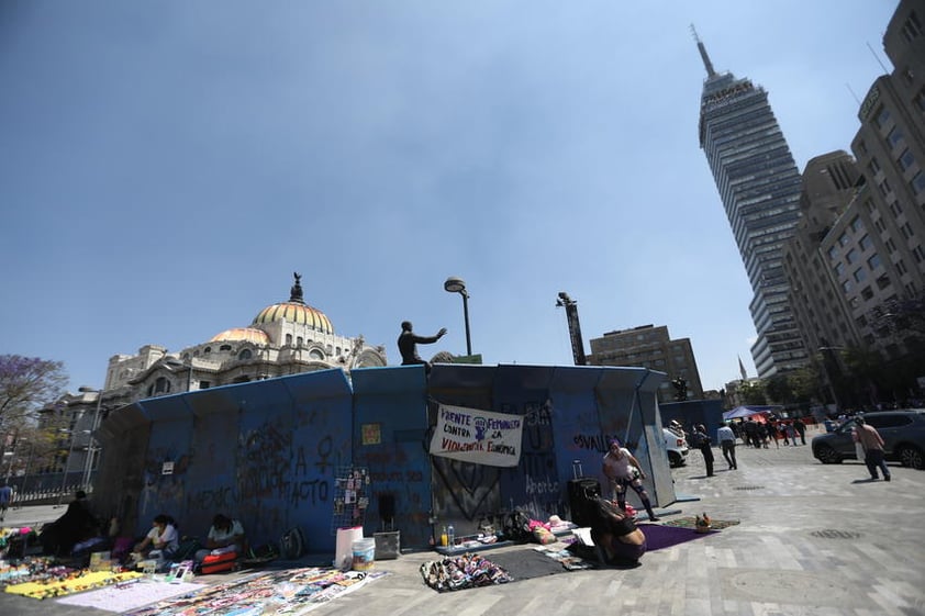 Vendedores ambulantes ofrecen hoy sus productos junto a unas vallas metálicas que rodean el Palacio de Bellas Artes,