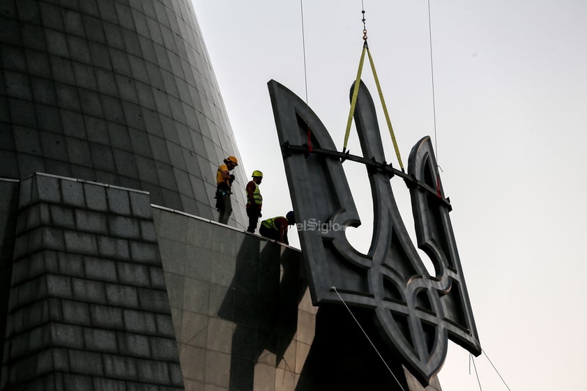 Los trabajadores se preparan para instalar el escudo de armas de Ucrania en el Monumento a la Patria del museo de la Segunda Guerra Mundial en Kiev, Ucrania, el 5 de agosto de 2023. El escudo de armas de Ucrania reemplaza a los de la era soviética instalados anteriormente y estará en su lugar el Día de la Independencia, que Ucrania marca el 24 de agosto de 2023.