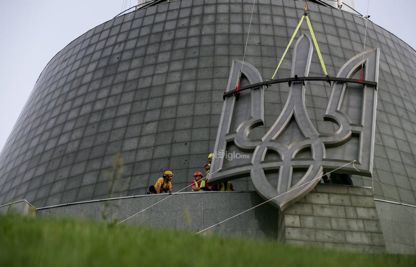 Los trabajadores se preparan para instalar el escudo de armas de Ucrania en el Monumento a la Patria del museo de la Segunda Guerra Mundial en Kiev, Ucrania, el 5 de agosto de 2023. El escudo de armas de Ucrania reemplaza a los de la era soviética instalados anteriormente y estará en su lugar el Día de la Independencia, que Ucrania marca el 24 de agosto de 2023.