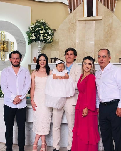 La pequeña Regina con sus papás, padrinos y su abuelo.