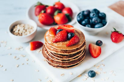 ¡Dale un giro divertido a tu desayuno! Mezcla dos plátanos maduros, huevos, leche, harina de avena, vainilla y canela. Sírvelos con una porción de fruta para un sabor más delicioso.