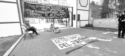 Situación. El joven José Amilcar cumplió su segundo día encadenado a las rejas de la entrada de la ByCENED; pasó la noche ahí, cubierto con un sarape.