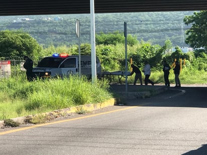 Elementos del Servicio Médico Forense (SEMEFO) retirando al cuerpo del lugar.