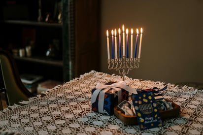 El hanukkiah, el cual se prende de izquierda a derecha y toma su llama de la vela central, la cual lleva por nombre shamash.