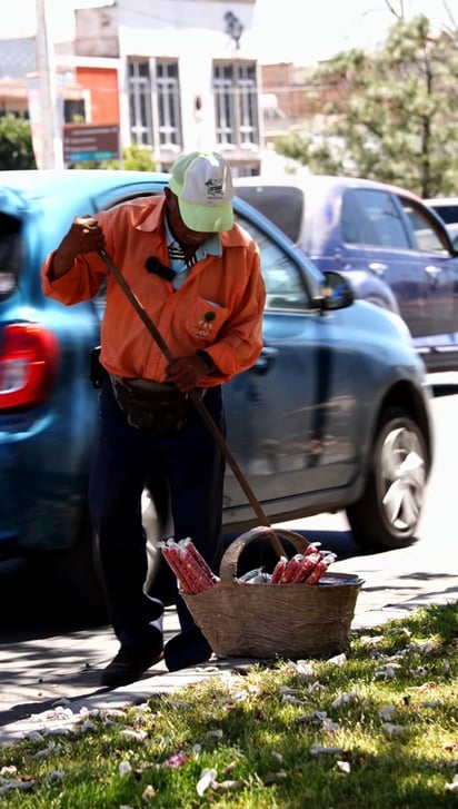 Barrer. Don Ubaldo barre todos los días la calle en donde suele vender sus dulces, para que así asegure que no lo van a correr.