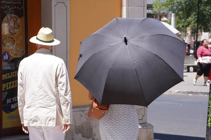 Alternativas. Los comerciantes, quienes están todo el día en la calle, buscan protegerse del sol mientras ofrecen sus productos a la clientela.