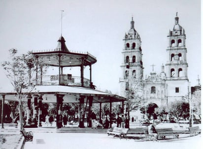 Vista histórica de la Plaza de Armas con su quiosco de hierro forjado al frente y la majestuosa Catedral Basílica de fondo. 