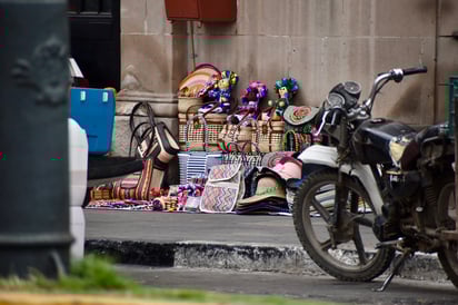 Hechos a mano. Artesanías y productos tradicionales acomodados sobre una manta reflejan la presencia activa de vendedores con diferentes raíces. Sus ofertas suman diversidad cultural al comercio callejero local.