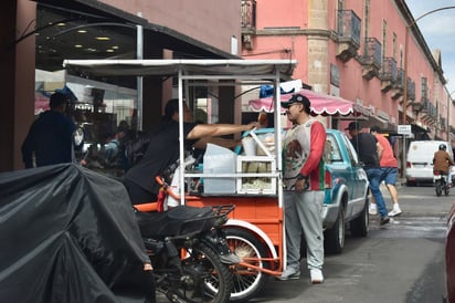 Clientes frecuentes. Estas interacciones breves muestran la dinámica diaria entre trabajadores informales y transeúntes.
