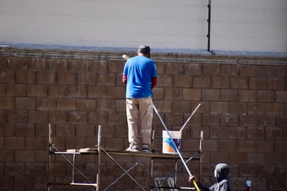 Oficio. Un pintor trabajando en el acabado de una fachada, labor que combina tanto equipo de trabajo como experiencia.