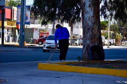 Esfuerzo constante. Una empleada realiza tareas escenciales para el funcionamiento de su local.