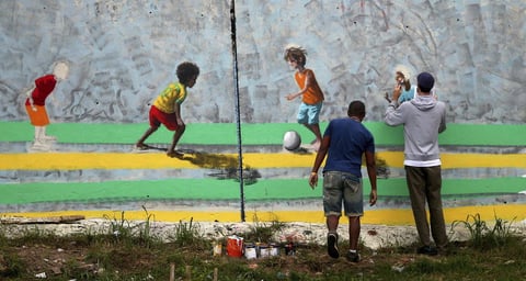Unos artistas pintan un mural en el barrio de Arena Corinthians en Sao Paulo, Brasil.