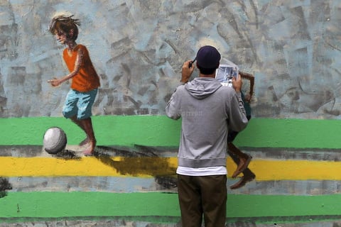 Un artista pinta un mural en el barrio de Arena Corinthians en Sao Paulo, Brasil.