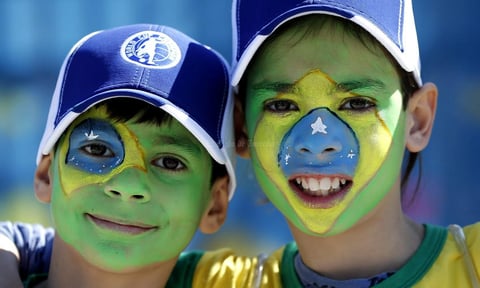 Unos ni&ntilde;os posan con sus rostros pintados como la bandera de Brasil frente al estadio Arena Corinthians en Sao Paulo, Brasil, hoy, jueves 12 de junio de 2014.