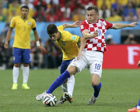 El centrocampista brasile&ntilde;o Oscar dos Santos (i) lucha un bal&oacute;n con el delantero croata Ivica Olic (d) durante el partido correspondiente al Grupo A del Mundial de F&uacute;tbol de Brasil 2014 que disputan en el estadio Arena de S&atilde;o Paulo.