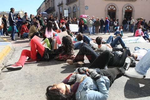 Sobre la calle 5 de Febrero, a la altura de la Plaza Fundadores, algunos j&oacute;venes estudiantes se tiraron al suelo para simular las figuras de los 43 normalistas desaparecidos.