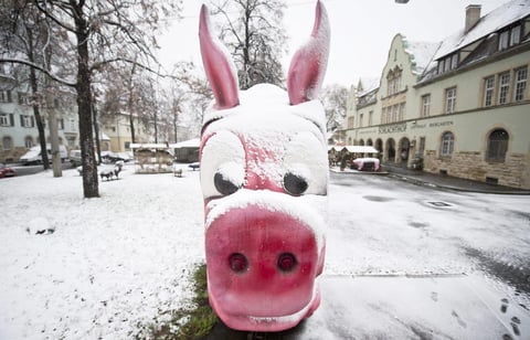La nieve cubre un tranv&iacute;a burl&aacute;ndose un cerdo en frente del Museo de cerdo en Stuttgart, Alemania.