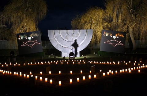 Un hombre hace fotos durante la celebración del Día Internacional de Conmemoración en Memoria del Holocausto en el cementerio judío cercano al campo de concentración de Terezin, República Checa.