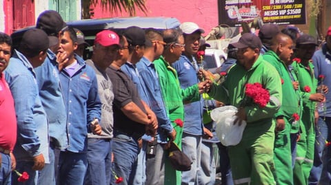 Trabajadores repart&iacute;an flores en las calles del centro.