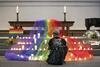 Varias personas depositan velas durante una vigilia por las 49 víctimas mortales, la mayoría hispanas, de la matanza perpetrada el pasado fin de semana en una discoteca de ambiente gay, celebrada en una iglesia de Zúrich, Suiza.